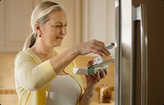 WOMAN LOOKING AT CARTON SHE TOOK FROM THE FRIDGE