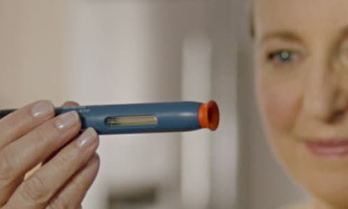 WOMAN EXAMINES AUTOINJECTOR