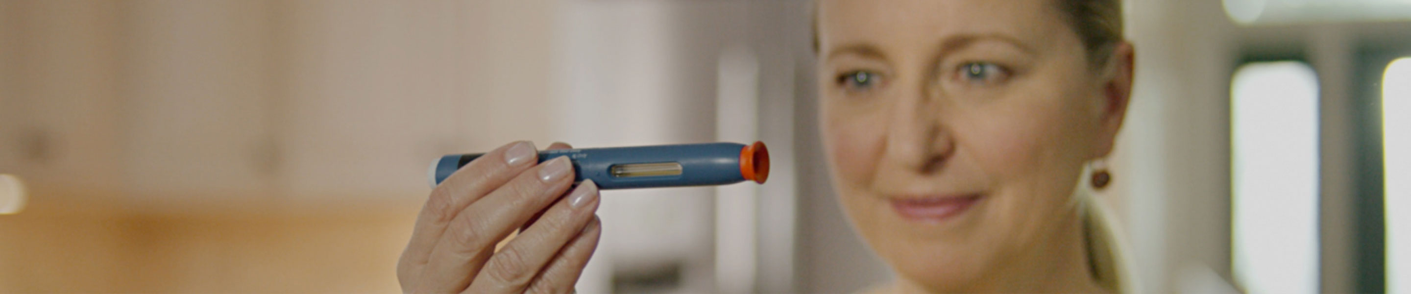 FEMME QUI EXAMINE L’AUTO-INJECTEUR