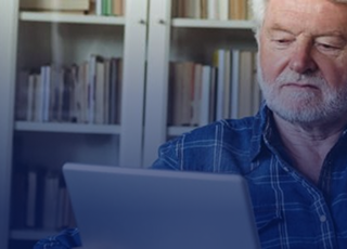MAN LOOKS AT HIS COMPUTER